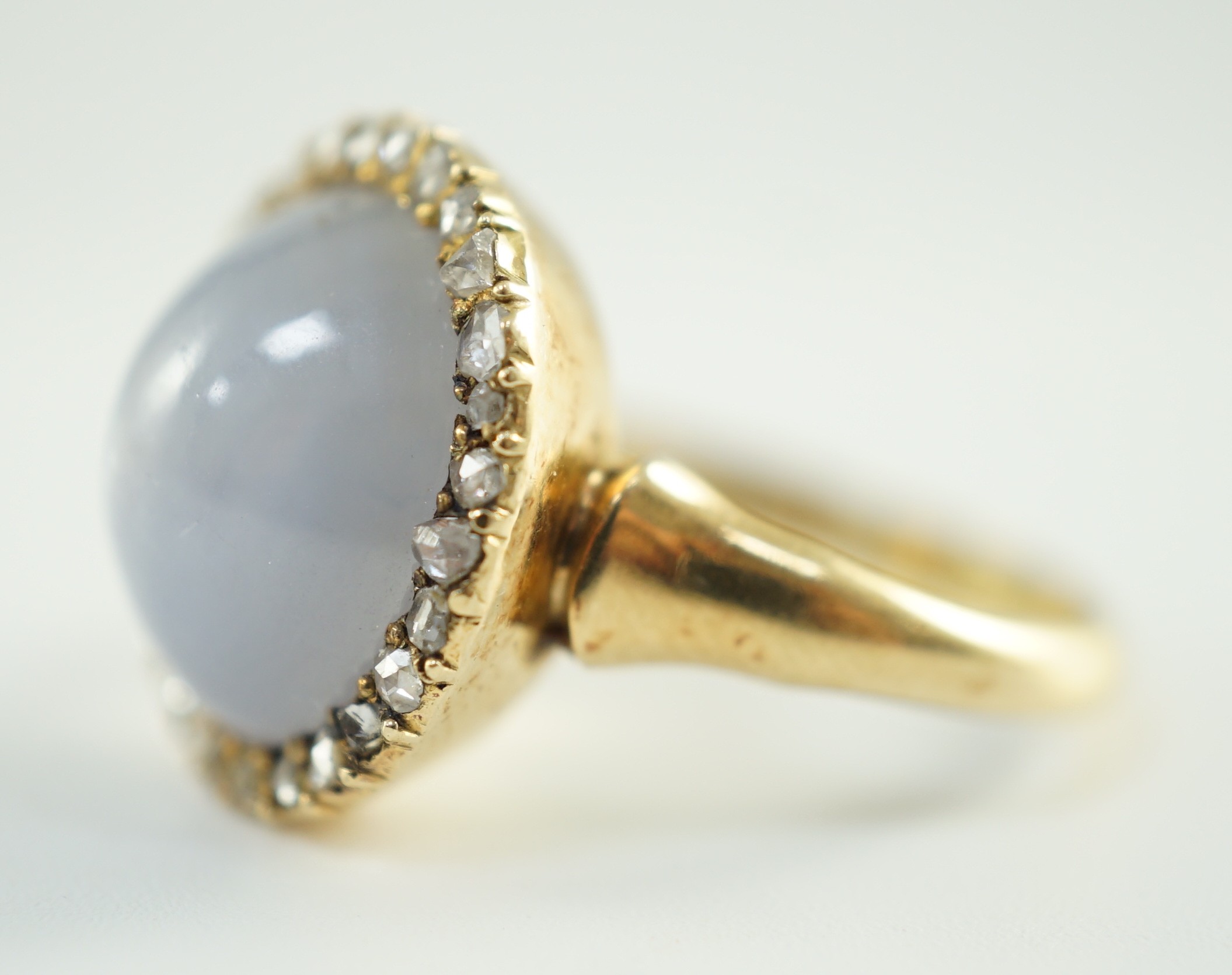 An early to mid 20th century 18ct gold, cabochon star sapphire and rose cut diamond set oval cluster ring